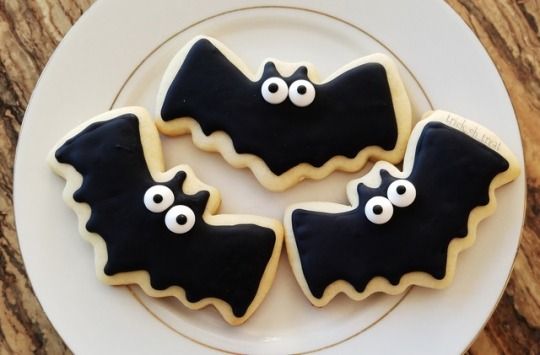 Whimsical Bat-Shaped Cookies with Black Icing and Candy Eyes for Halloween Celebrations