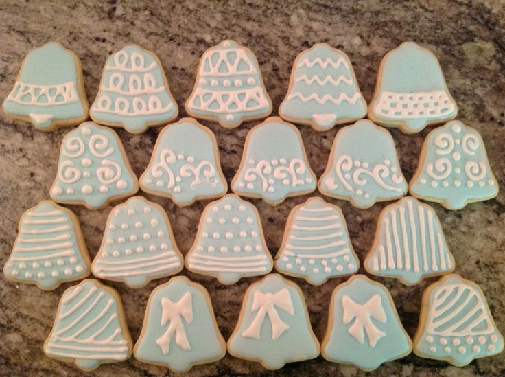 Festive Bell-Shaped Cookies: Light Blue Icing with Intricate White Piping and Charming Patterns for Holiday Celebrations.