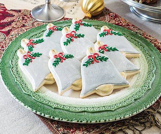 Charming Holiday Display of Festive Bell-Shaped Cookies with Silver Icing and Decorative Accents.