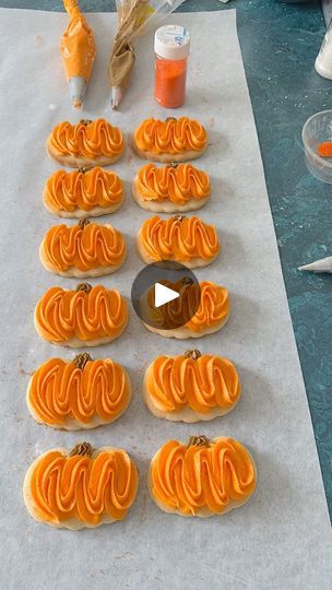 Festive Pumpkin-Shaped Cookies with Vibrant Orange Frosting and Textured Design.