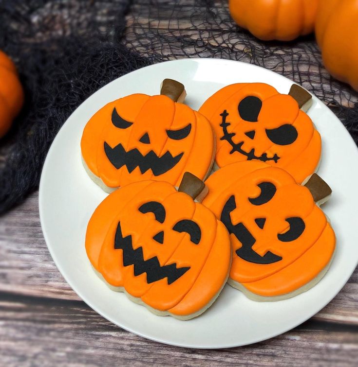 Vibrant Halloween Cookies with Playful Jack-o'-Lantern Designs on White Plate