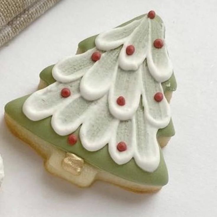 Festive Christmas Tree Cookies with Green and White Frosting and Red Ornaments.