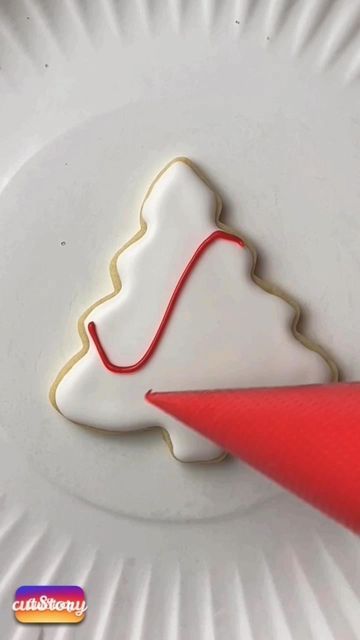 Cheerful Frosted Christmas Tree Cookie Design with Red Piping Accents.