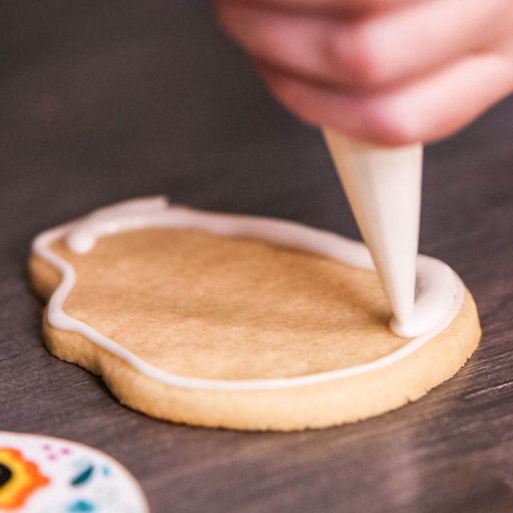 Skillful Precision in Decorative Cookie Icing Application.