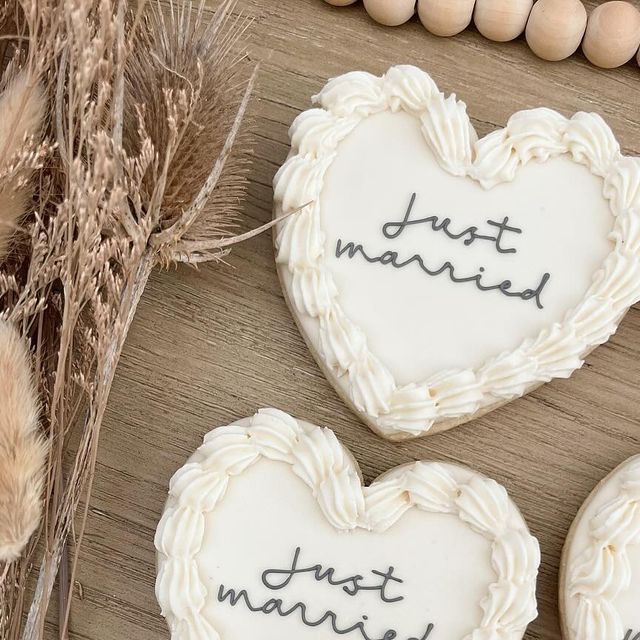 Elegant Heart-Shaped Wedding Cookies with Creamy Icing and Rustic Floral Accents.