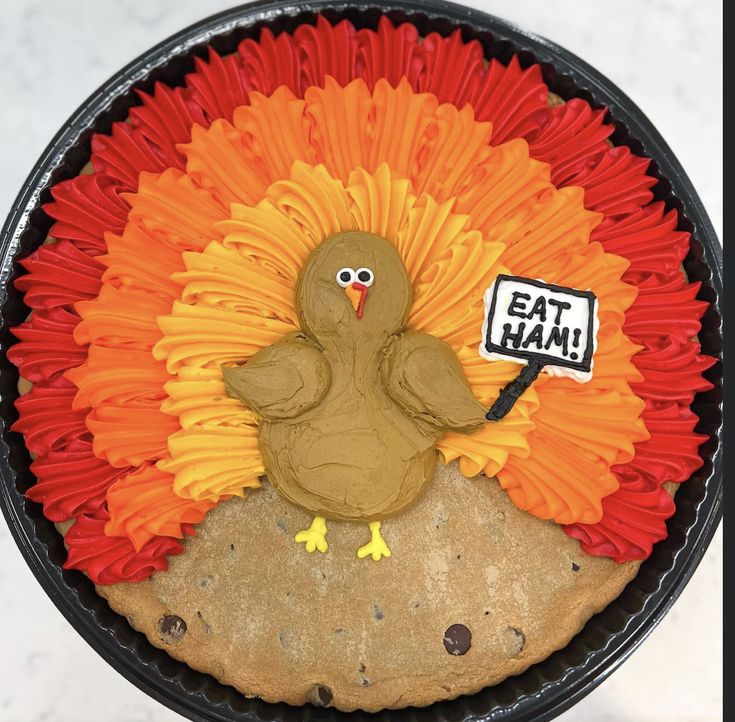 Whimsical Turkey Design Festive Cookie Cake with Vibrant Icing and Humorous Sign.