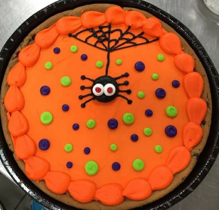 Vibrant Cookie Cake Adorned with Orange Icing, Whimsical Spider, and Festive Dots for Seasonal Celebrations.