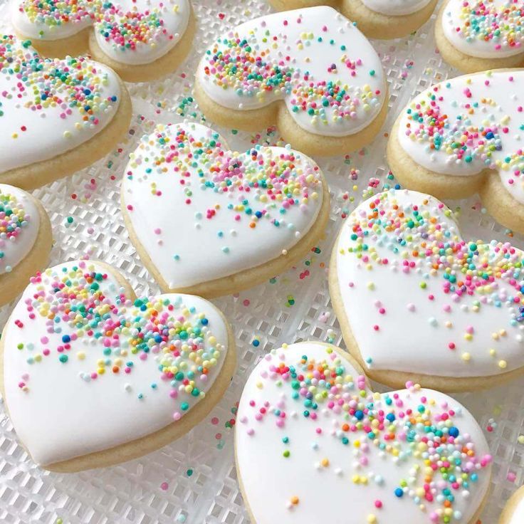 Whimsical Heart-Shaped Cookies with Colorful Sprinkles and Smooth Icing.