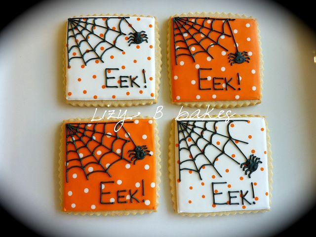 Vibrant Halloween Cookies with Intricate Spider Web Designs and Festive Touches.