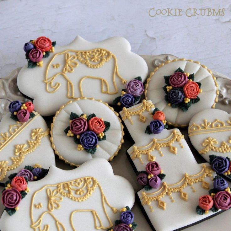 Elegant Decoratively Adorned Cookies with Intricate Elephant and Floral Designs in Vibrant Colors.