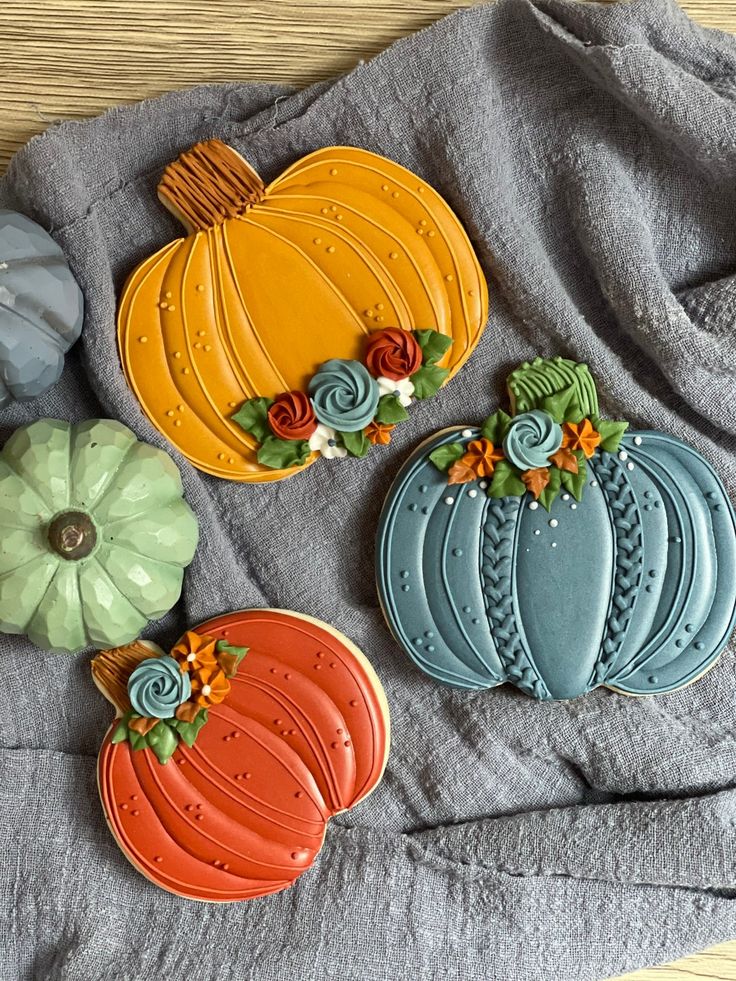 Whimsical Autumn Pumpkin-Shaped Cookies Adorned with Intricate Icing and Floral Accents.