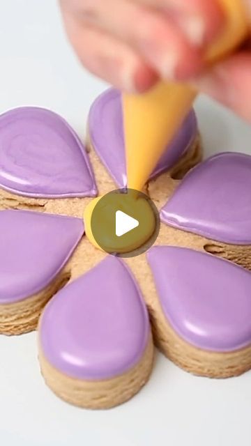 Pastel Purple and Yellow Flower-Shaped Cookies: Elegant Petal Design with Shiny Icing for Celebrations.