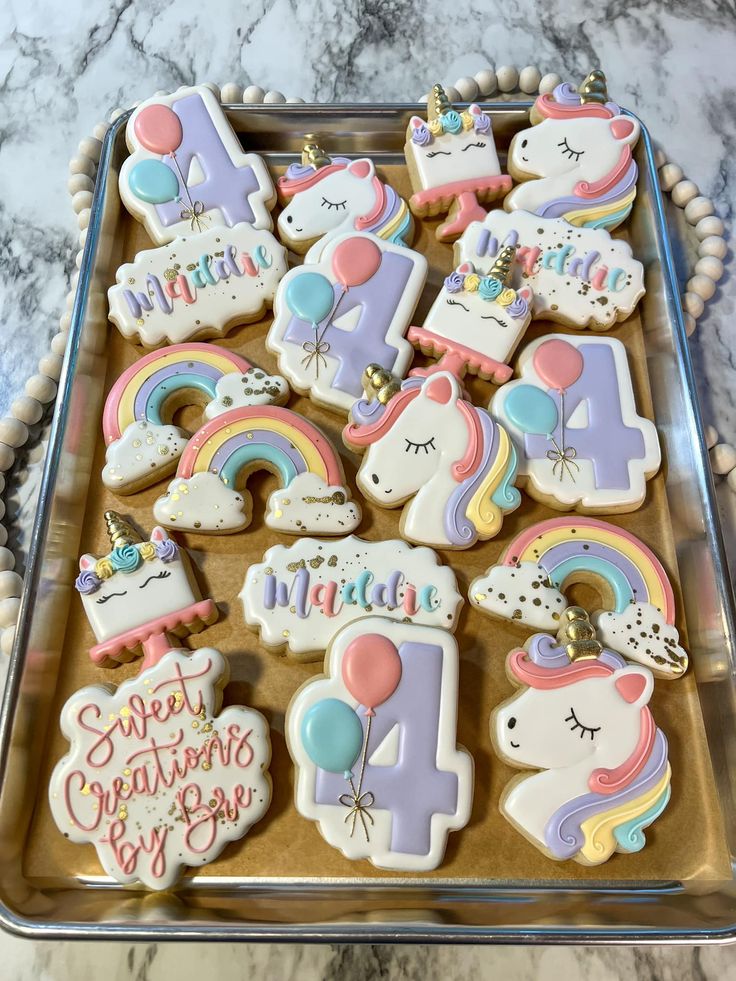 Whimsical Unicorn and Rainbow Cookies: A Festive Celebration Design on a Metallic Tray.