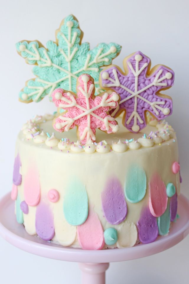 Festive Colorful Cake Decorated with Whimsical Snowflake Cookies and Soft Pastel Hues.