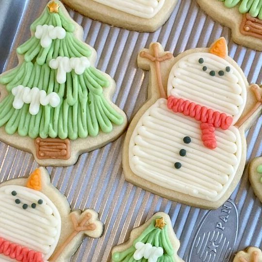 Whimsical Festive Cookie Designs: Playful Snowman and Christmas Tree Treats Decorated with Vibrant Holiday Icing.