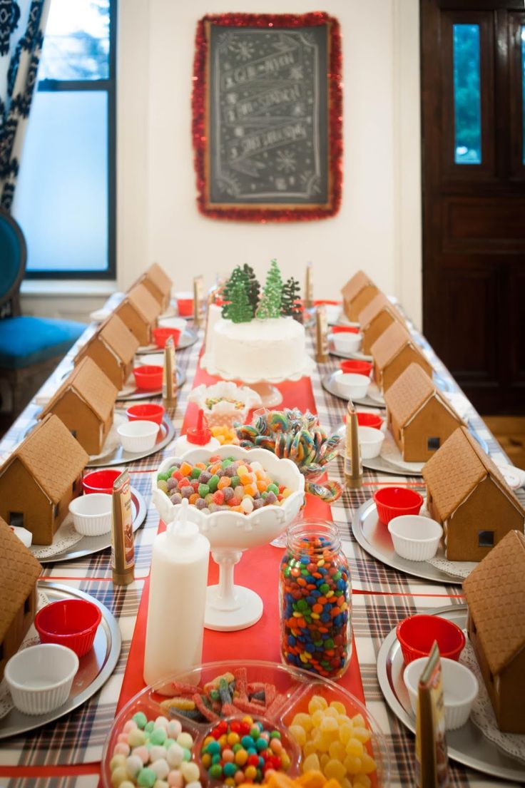 Charming Holiday Table Setting with Gingerbread Houses and Colorful Candy Arrangements.