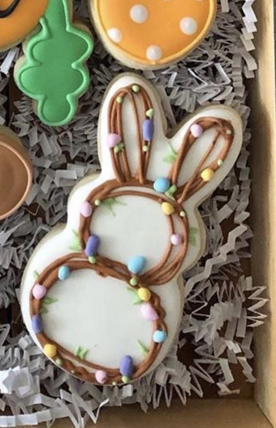 Whimsical Easter Bunny Cookie with Pastel Egg Decorations and Wreath Design.