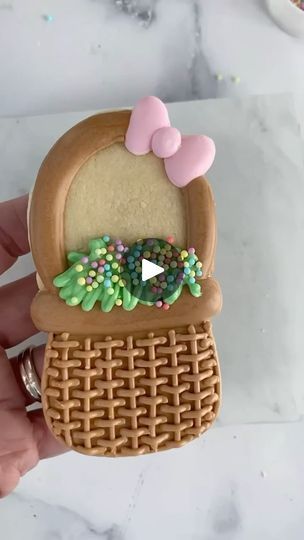 Festively Decorated Cookie Shaped Like a Basket with Pink Bow and Colorful Sprinkles.