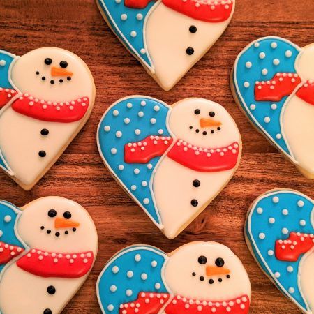 Festive Heart-Shaped Snowman Cookies with Whimsical Designs and Bright Icing