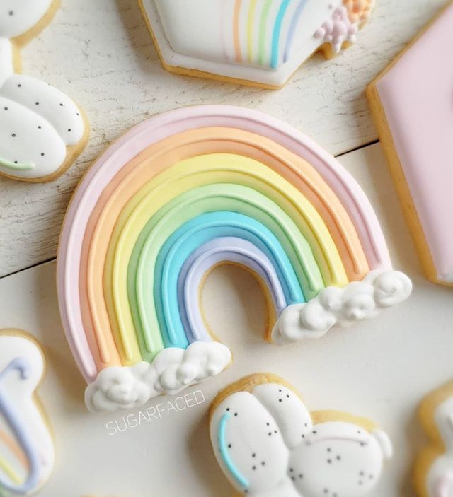 Whimsical Rainbow Cookie Design in Soft Pastels with Fluffy White Clouds.