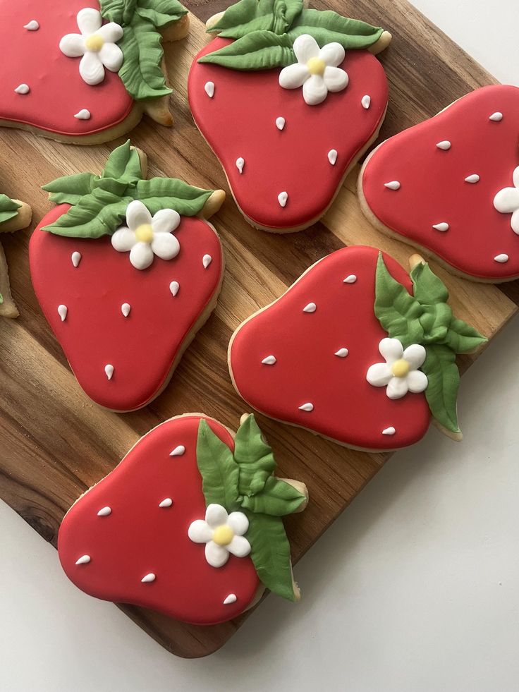 Vibrant Strawberry-Shaped Cookies: Playful Design with Red Icing and Floral Accents, Perfect for Festive Events.