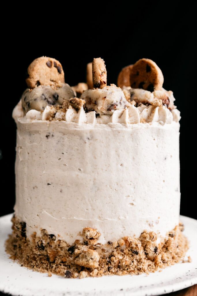 Decadent Layered Cookie Dough Cake with Vanilla Frosting and Mini Chocolate Chip Cookie Topping.