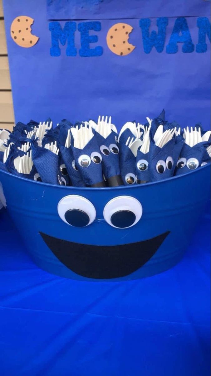 Whimsical Blue Bucket Utensil Holder with Googly Eyes for a Cheerful Gathering.