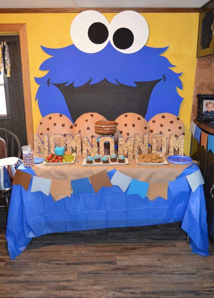 Whimsical Dessert Table Against Bright Yellow Wall Featuring Playful Cookie Monster Graphic.