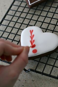 Heart-Shaped Cookie: White Icing with Vibrant Red Designs for Special Occasions.