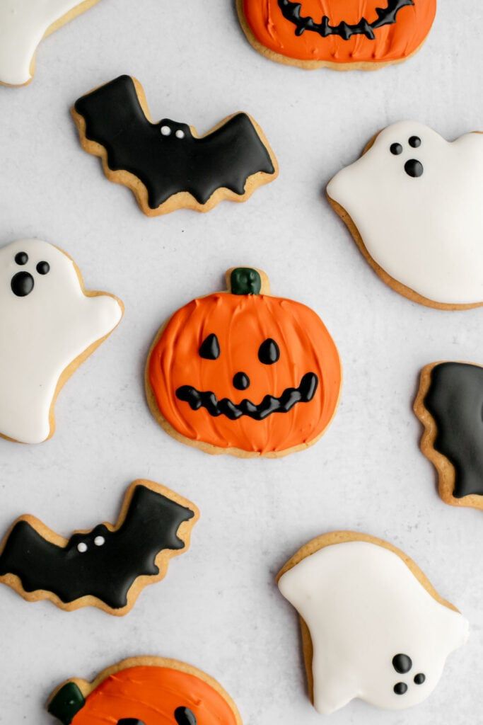 Whimsical Halloween Cookies: Festive Pumpkin, Ghost, and Bat Designs in Vibrant Colors.