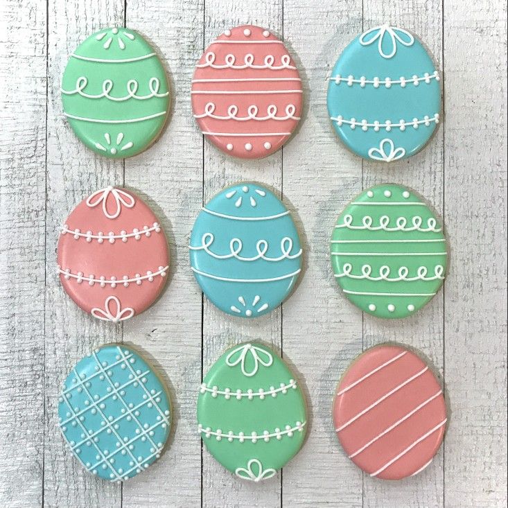 Pastel Egg-Shaped Cookies with Intricate White Icing for Spring Celebrations.