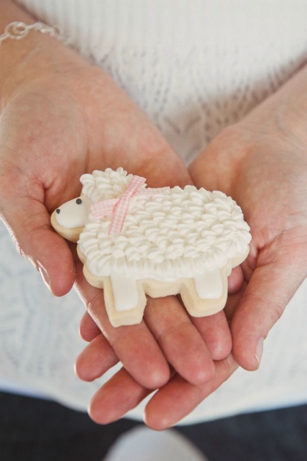 Charming Whimsical Sheep-Shaped Cookie with Fluffy Icing and Cute Ribbon for Events.