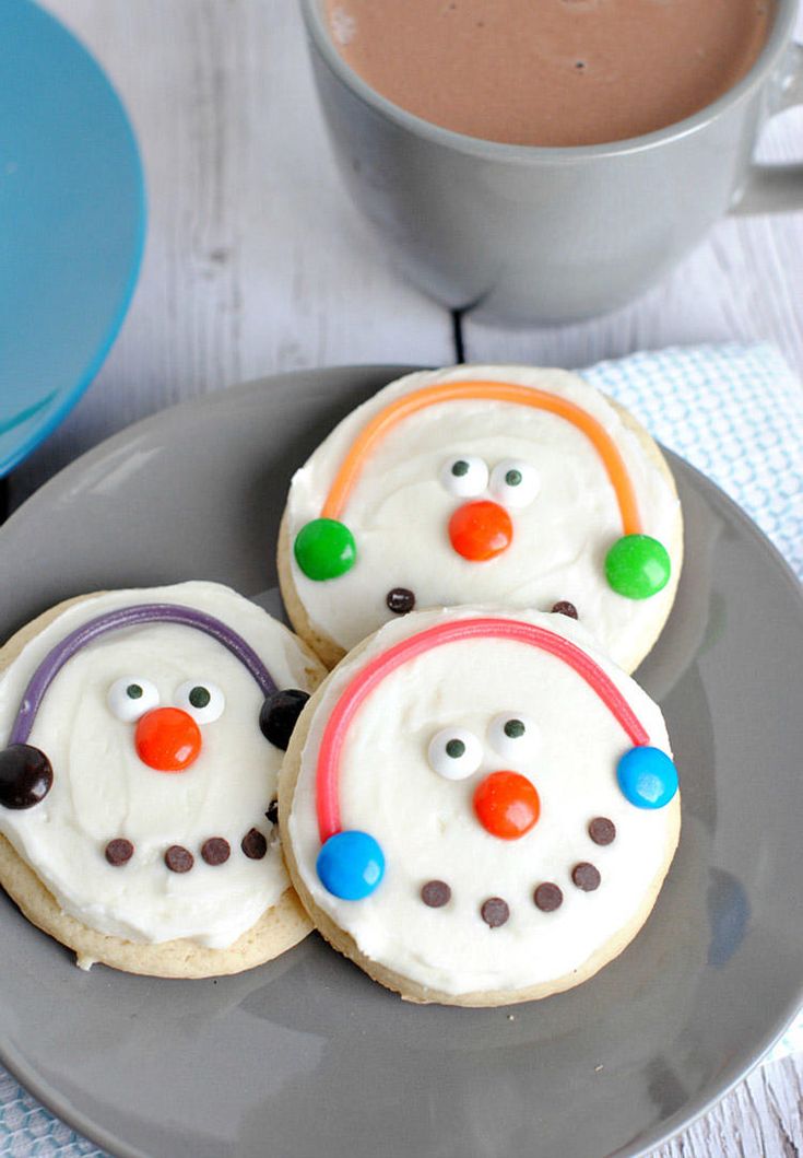 Cheerful Snowman Cookies with Whipped Frosting and Colorful Candy Faces Accompanied by Cozy Hot Chocolate.