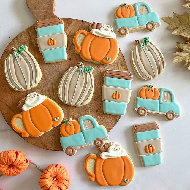 Artfully Arranged Autumn-Themed Cookies on a Wooden Platter with Vibrant Orange and Teal Hues.