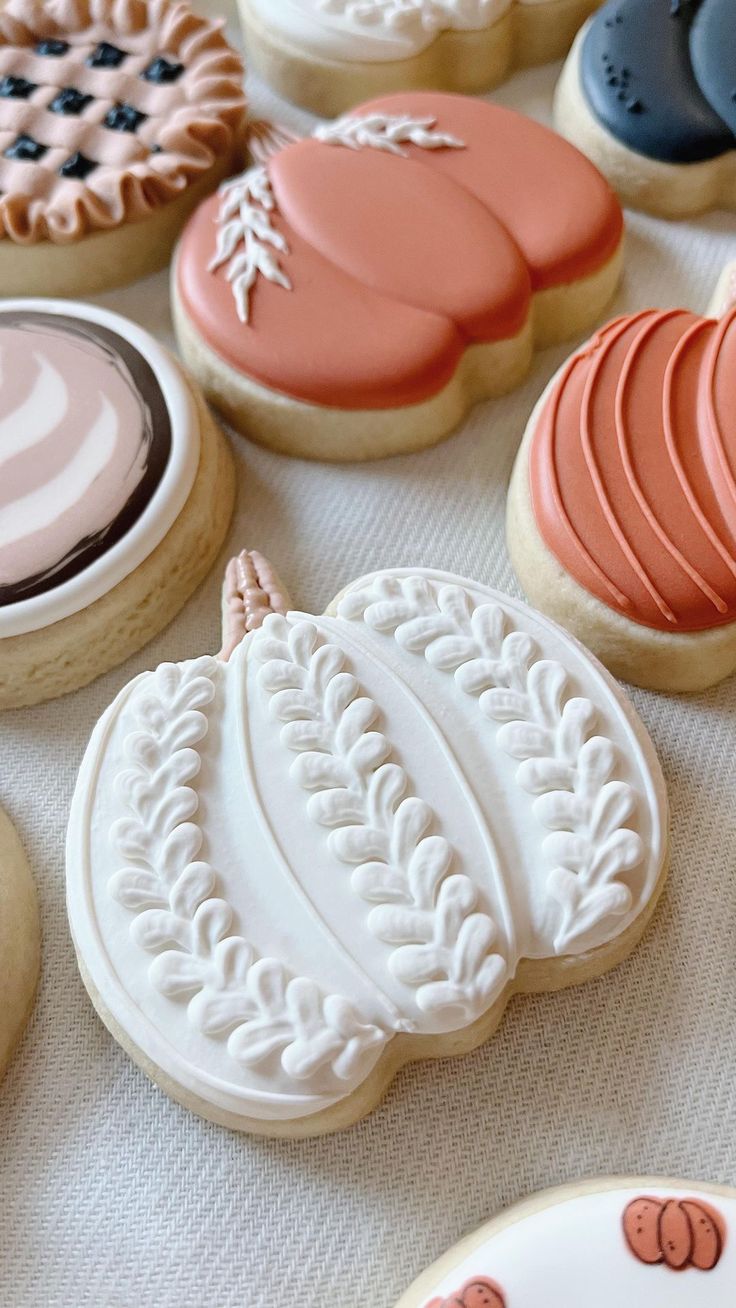 Autumn-Inspired Decorative Sugar Cookies with Intricate Designs and a Textured White Pumpkin.