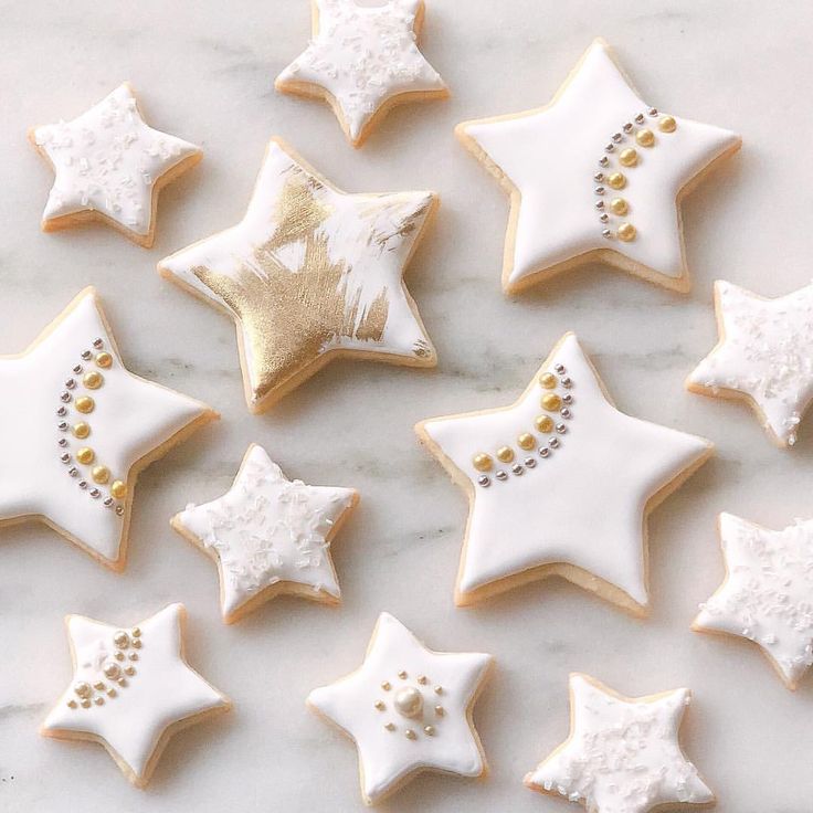 Elegant Star-Shaped Cookies with White Icing and Gold Accents: A Festive Delight for Special Occasions.