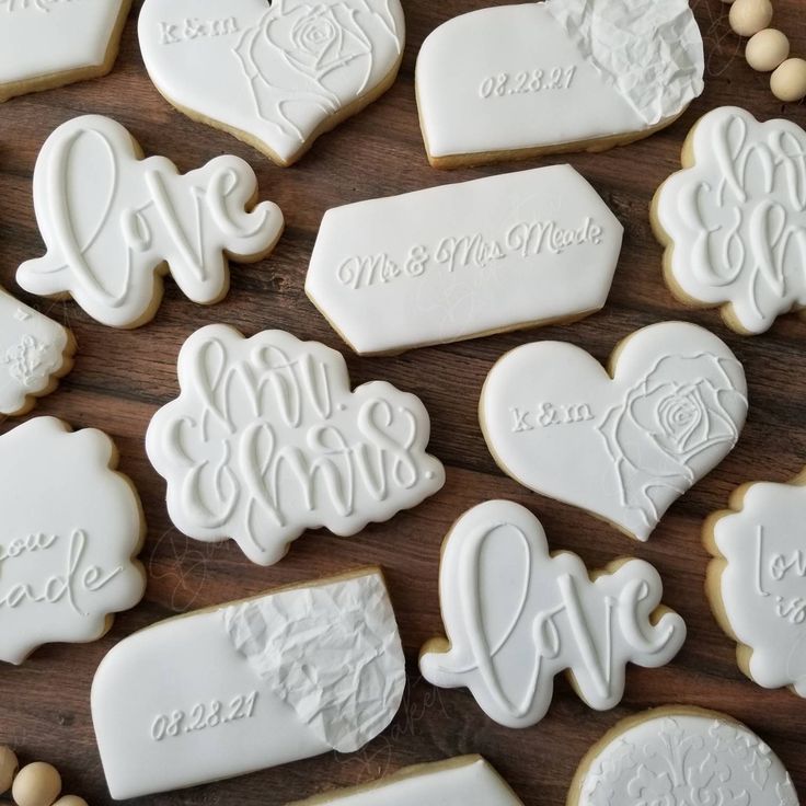 Elegant Decorative Cookies with Intricate Lettering and Floral Patterns for Special Occasions.