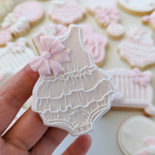 Whimsical Baby Dress Cookies: Delicate Pastel Decor for Celebrations.