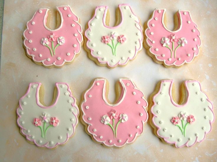 Whimsical Bib-Shaped Cookies Adorned with Floral Designs for Celebrations.