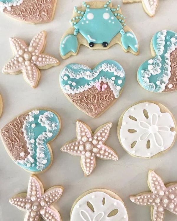 Coastal-Inspired Colorful Cookie Designs: Starfish, Crab, and Heart Shapes with Pastel Icing.