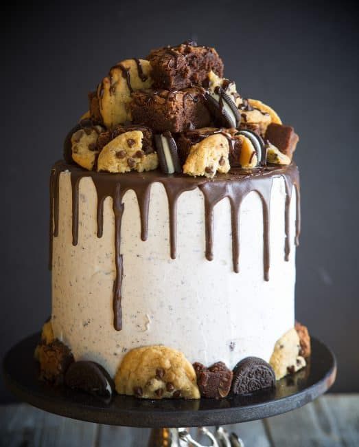 Indulgent Tall Cake: Creamy Vanilla Frosting and Rich Chocolate Ganache with Cookies and Brownies Topping