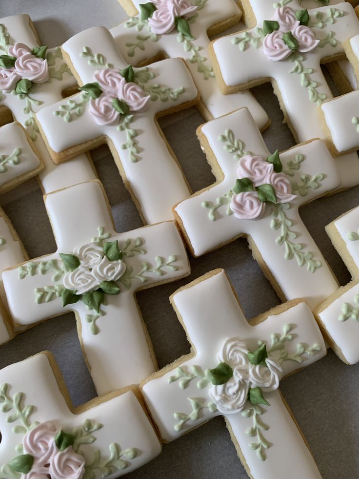 Elegant Cross-Shaped Cookies Adorned with Delicate Floral Icing for Special Occasions.