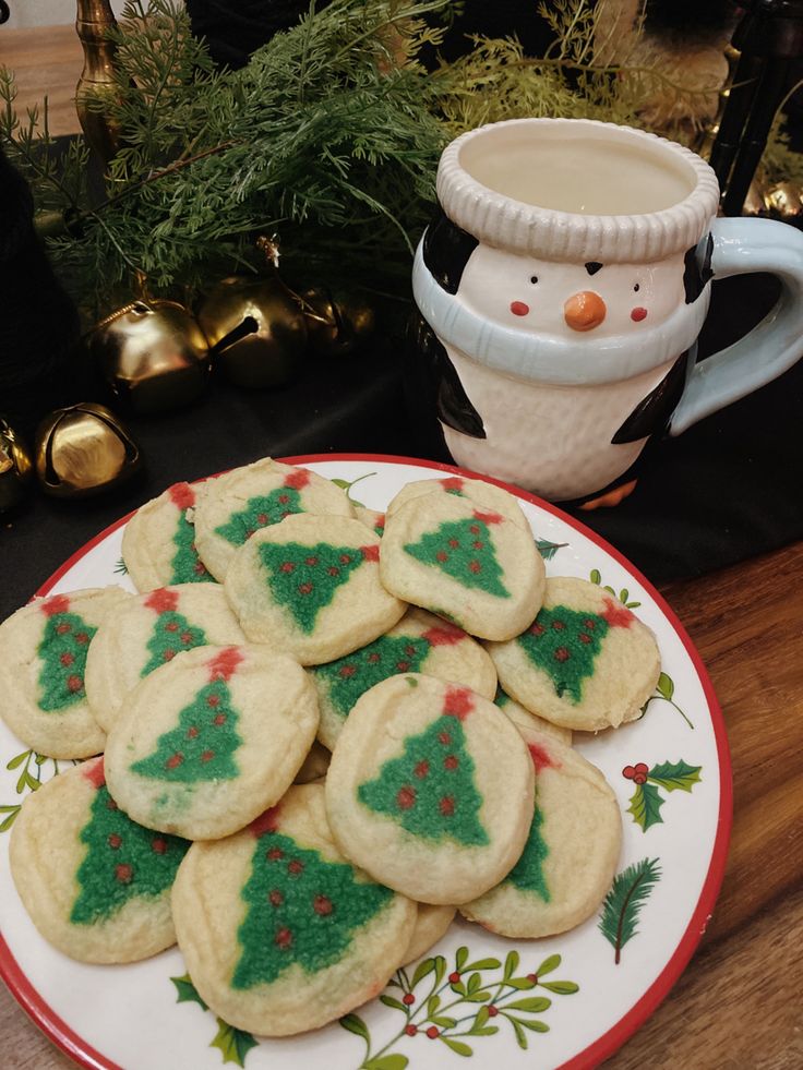 Cheerful Festive Cookie Display with Christmas Trees and Penguin Mug for Holiday Gatherings.