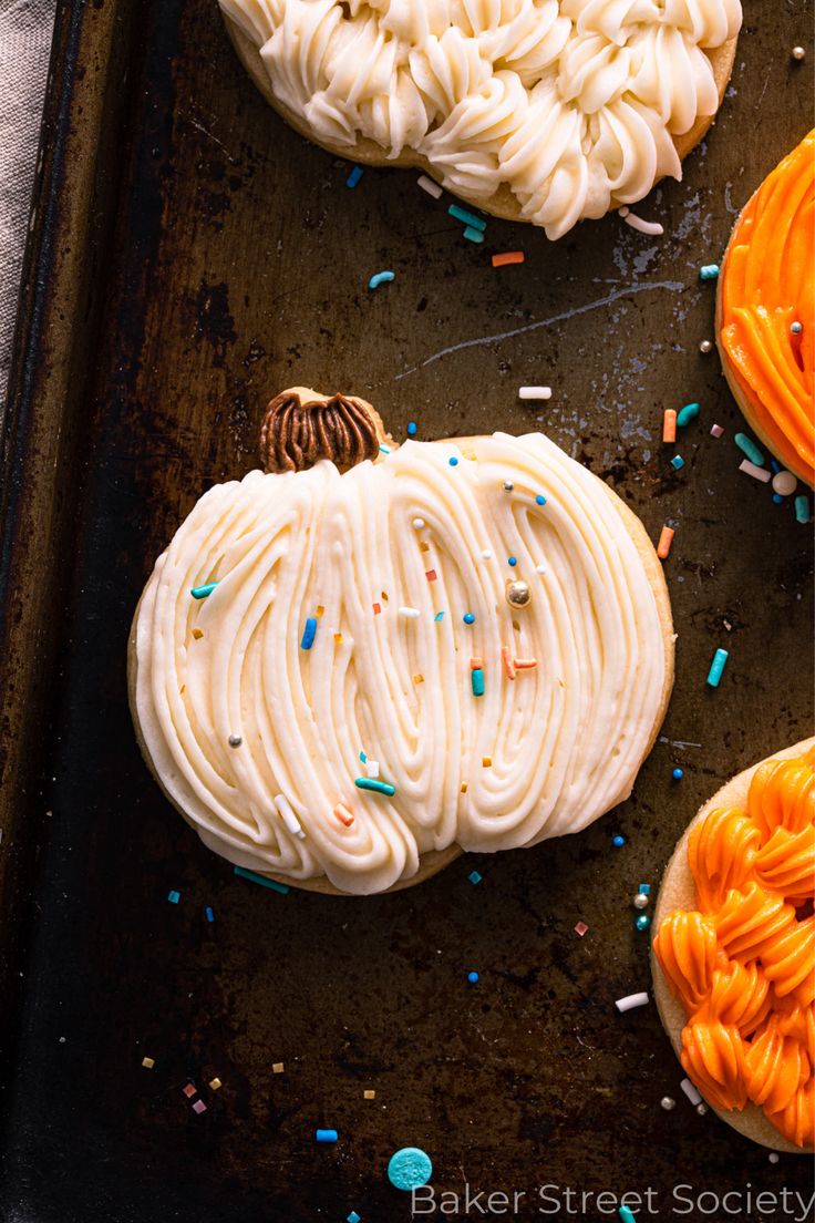 Festive Pumpkin-Shaped Cookies with Creamy Frosting and Colorful Sprinkles.