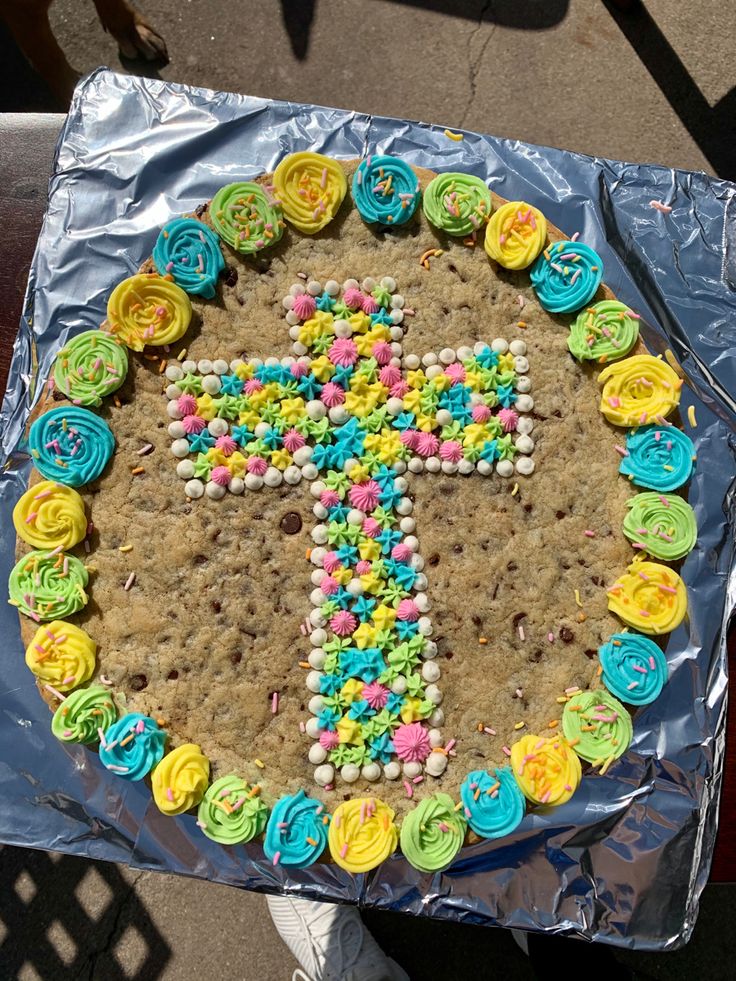 Vibrant Cookie Cake with Pastel Cross Design and Frosting Border Perfect for Celebrations.