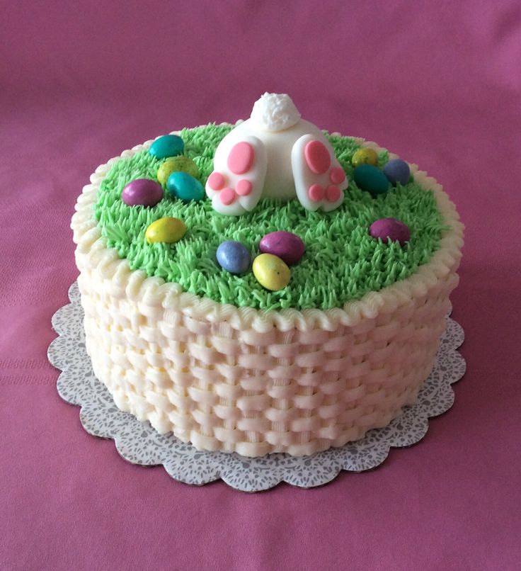 Whimsical Spring Cake Adorned with Pastel Candy Eggs and Bunny Butt Decor.