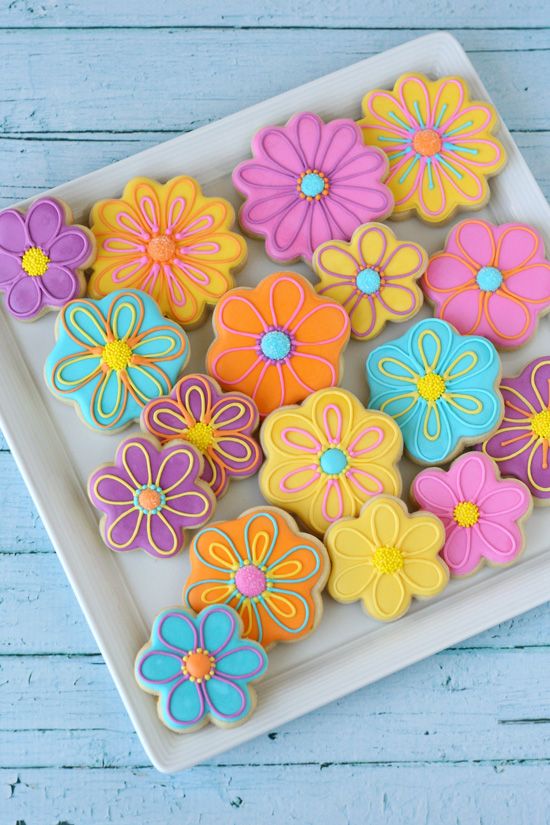 Vibrant Flower-Shaped Cookies Adorned with Intricate Icing for Cheerful Celebrations.