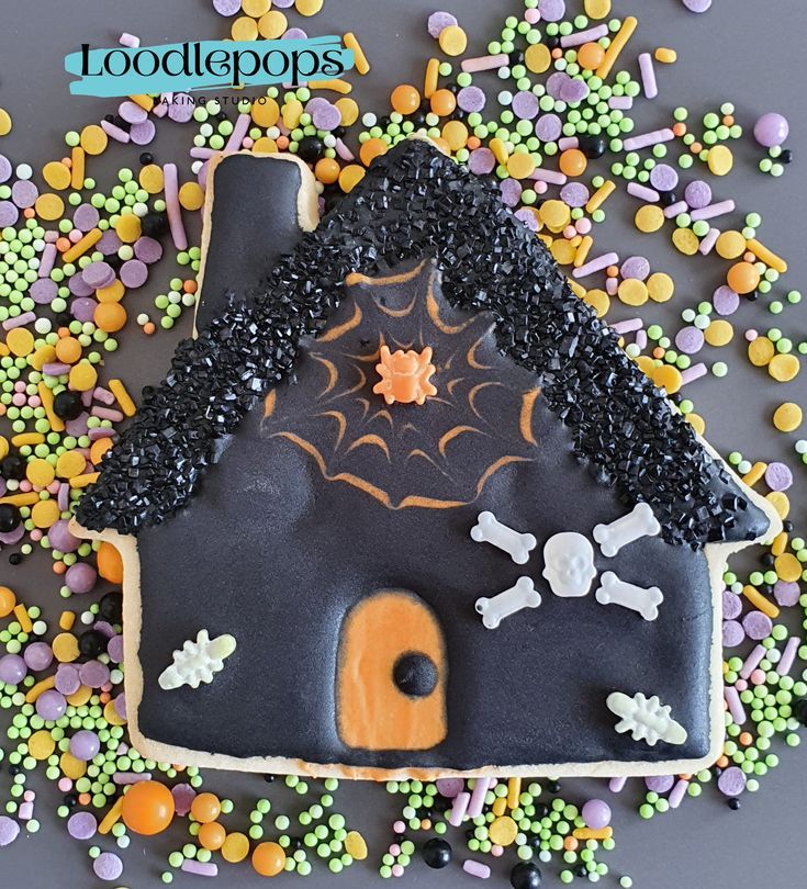 Haunted House Halloween Cookie: A Whimsical Treat with Spider Web Icing and Vibrant Candies.