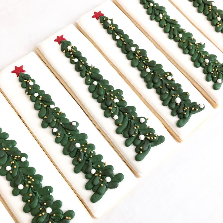 Charming Christmas Nail Art: Festive Green Foliage with White, Gold Accents, and Bright Red Stars.