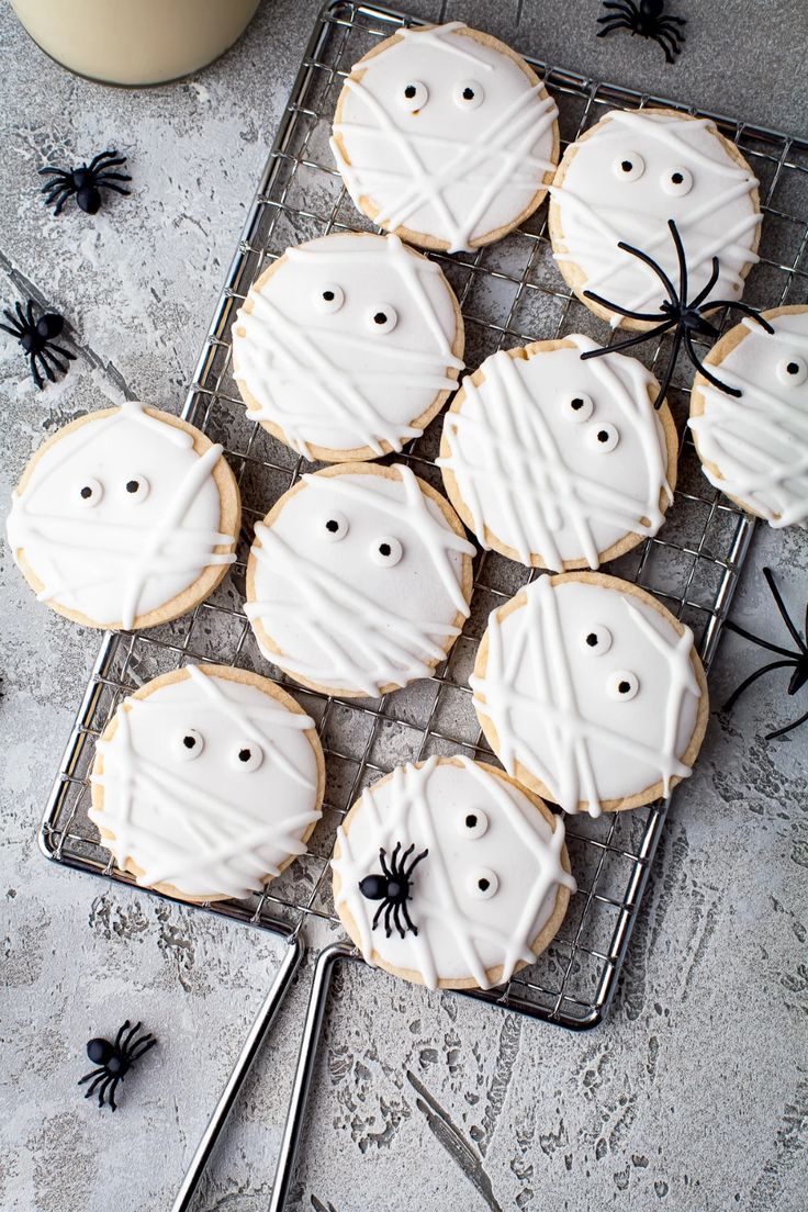 Halloween Mummy Cookies: Festively Iced Delights with Spooky Spider Accents.